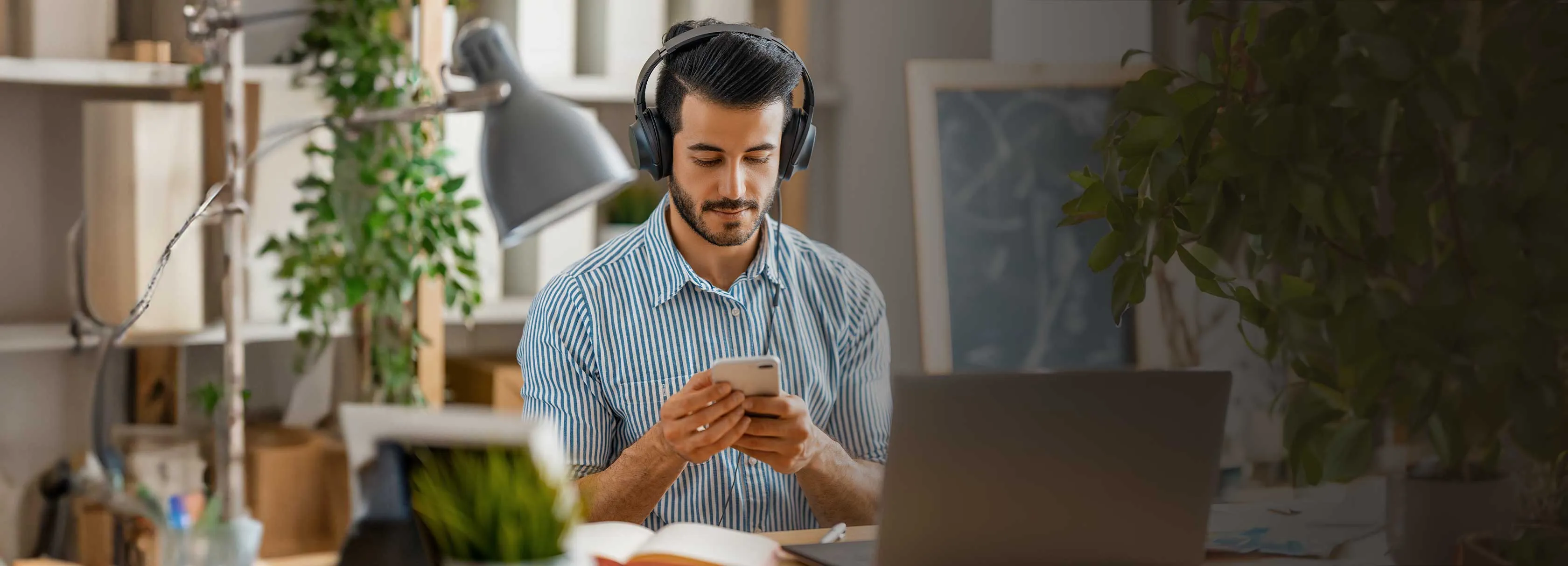 A man wearing headphones and using his phone